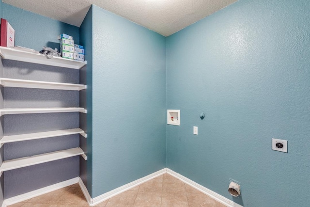 253 Lear Ave, Buda, TX 78610 - washroom with hookup for an electric dryer, hookup for a washing machine, tile patterned floors, hookup for a gas dryer, and a textured ceiling