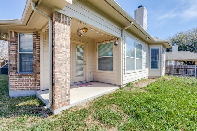 253 Lear Ave, Buda, TX 78610 - view of exterior entry featuring brick siding, a patio, and a chimney