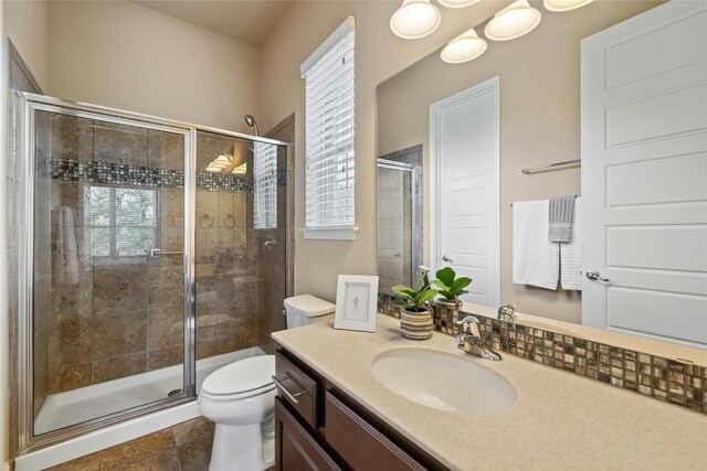 bathroom featuring tile patterned flooring, vanity, an enclosed shower, and toilet