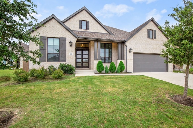 view of front of home with french doors, a front yard, and a garage