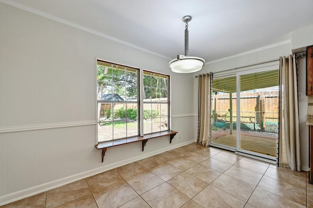 empty room featuring light tile patterned floors and crown molding