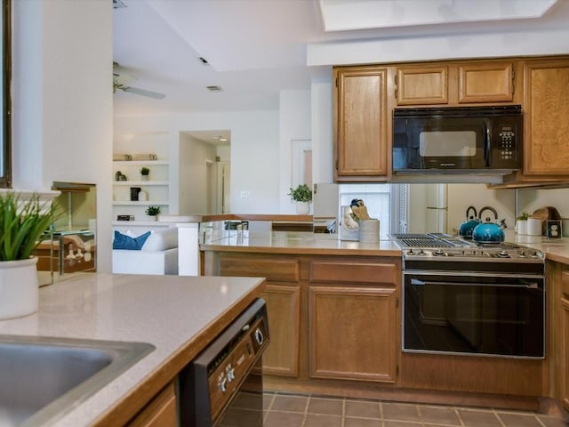 kitchen with kitchen peninsula, dark tile patterned flooring, ceiling fan, and black appliances