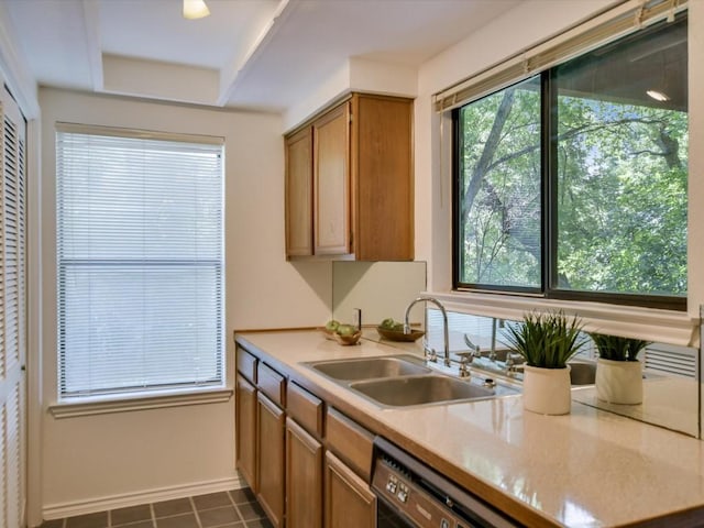 kitchen with dishwashing machine, sink, and dark tile patterned floors