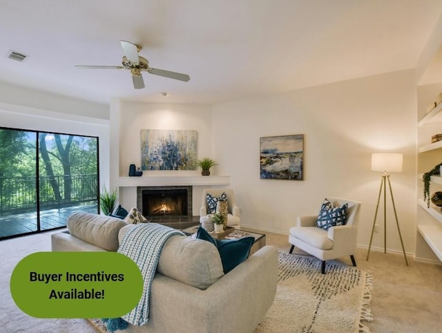 carpeted living room featuring ceiling fan and a tile fireplace