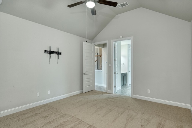 carpeted spare room featuring vaulted ceiling and ceiling fan