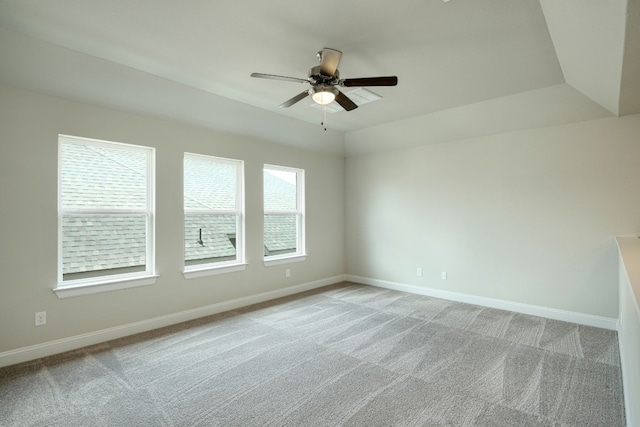 carpeted empty room featuring a tray ceiling and ceiling fan