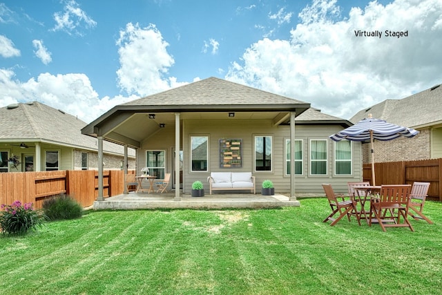 rear view of house featuring a lawn and a patio