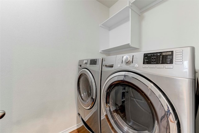 clothes washing area with washer and dryer and wood-type flooring