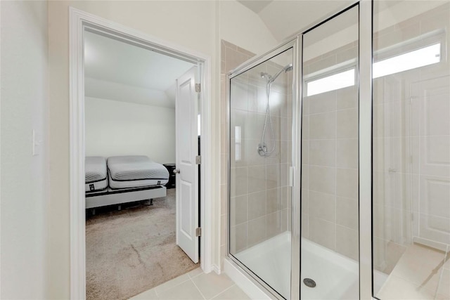 bathroom with tile patterned flooring, vaulted ceiling, and walk in shower