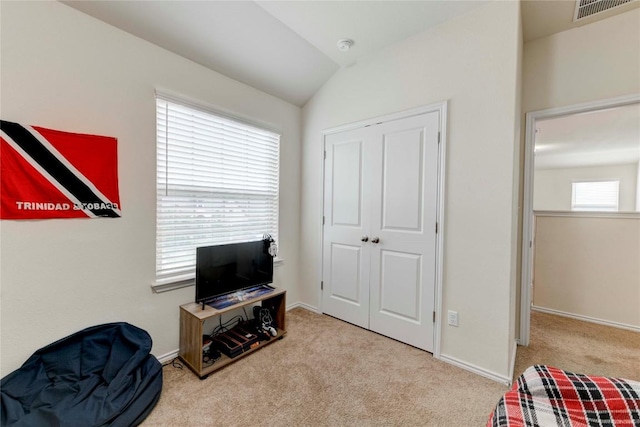 living area with a wealth of natural light, light colored carpet, and lofted ceiling