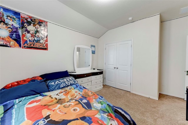 carpeted bedroom with a closet and lofted ceiling