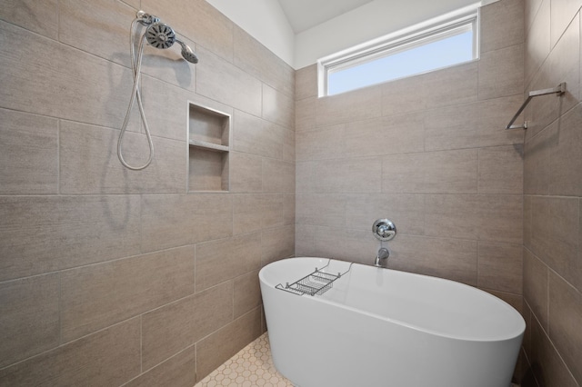 bathroom featuring a bathing tub, lofted ceiling, tile patterned flooring, and tile walls