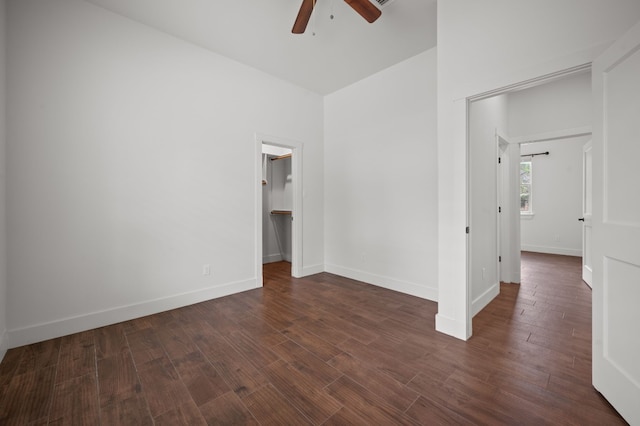unfurnished room with ceiling fan, dark wood-type flooring, and baseboards