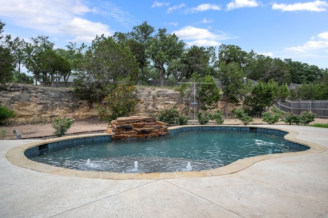 view of pool featuring pool water feature and a patio