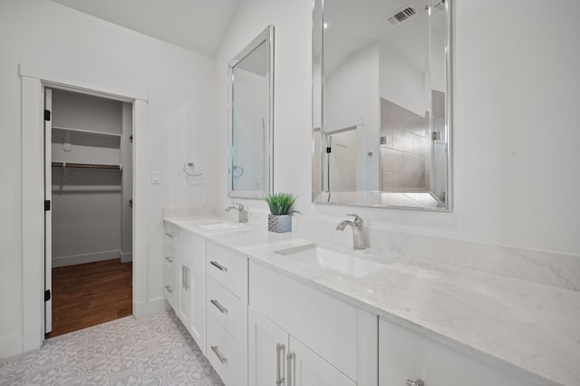 bathroom featuring vanity, hardwood / wood-style flooring, and vaulted ceiling