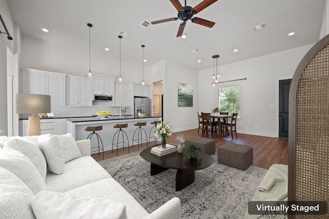 living room with ceiling fan and dark hardwood / wood-style flooring