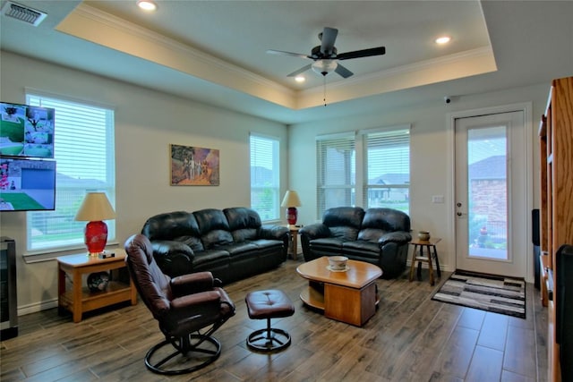 living room with a tray ceiling, ceiling fan, and crown molding