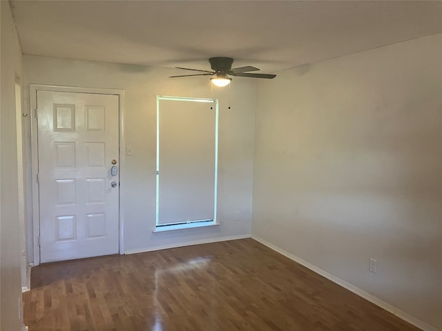 unfurnished room featuring wood finished floors, a ceiling fan, and baseboards