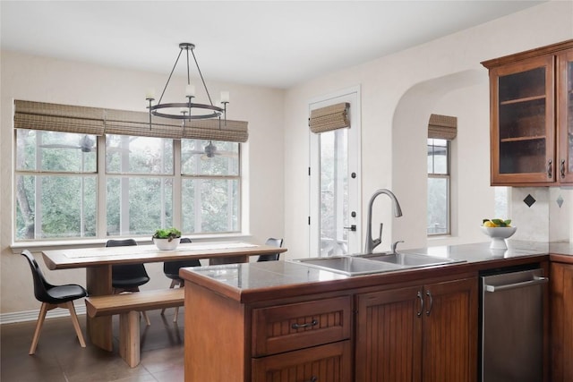 kitchen featuring kitchen peninsula, a wealth of natural light, sink, and decorative light fixtures