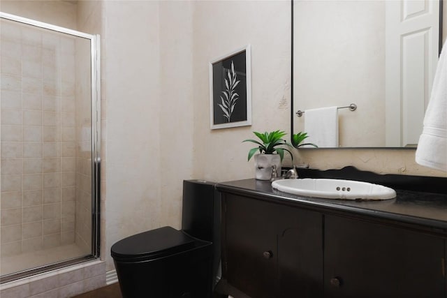 bathroom featuring toilet, vanity, and walk in shower