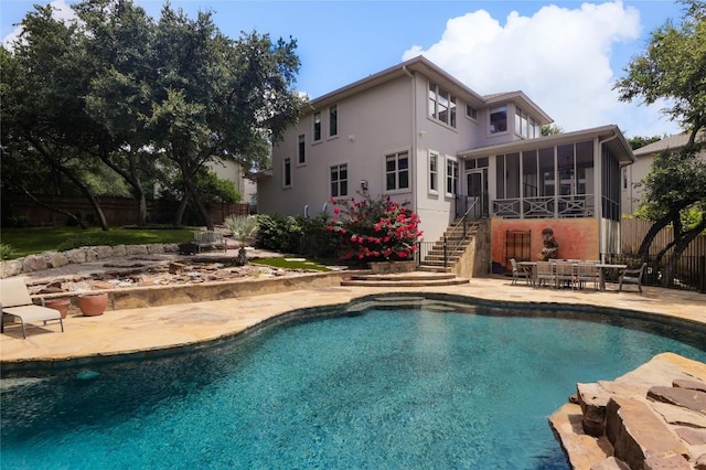 view of pool featuring a sunroom and a patio