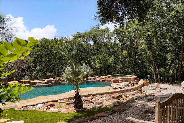 view of swimming pool with an in ground hot tub