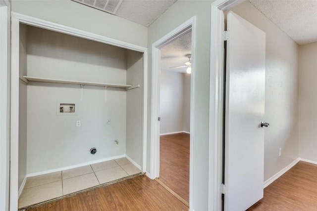 laundry area with a textured ceiling, light wood-type flooring, hookup for a washing machine, electric dryer hookup, and ceiling fan