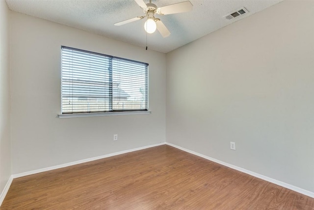 spare room with ceiling fan, hardwood / wood-style flooring, and a textured ceiling