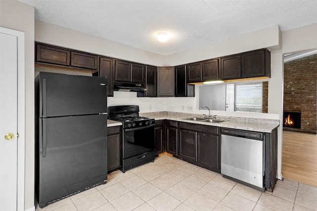 kitchen featuring dark brown cabinetry, sink, a textured ceiling, light tile patterned floors, and black appliances