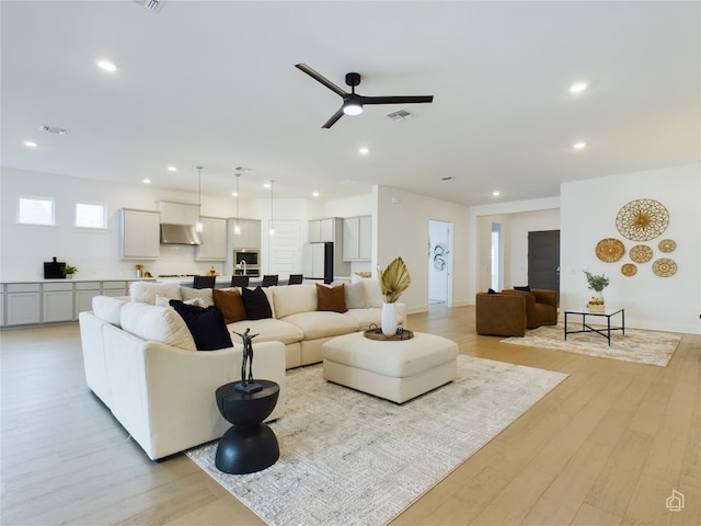 living room featuring light wood-type flooring and ceiling fan