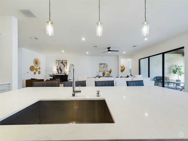 kitchen featuring ceiling fan, sink, and pendant lighting