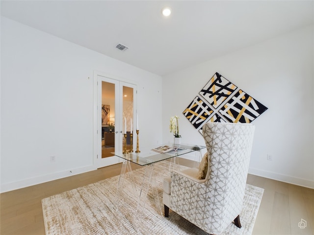 sitting room featuring wood-type flooring and french doors