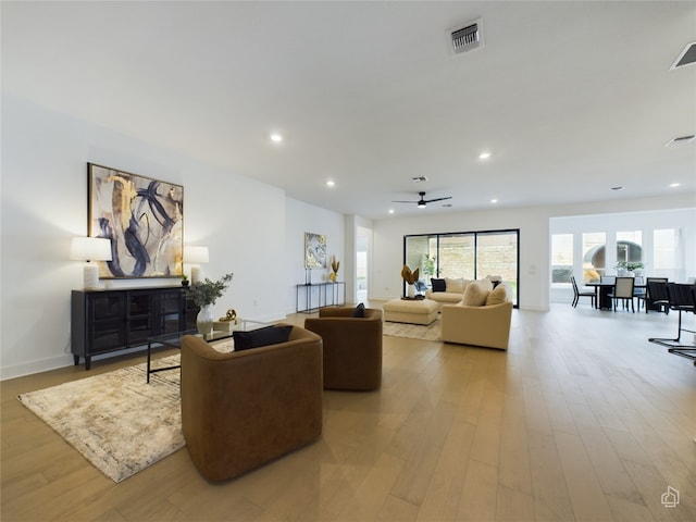 living room featuring ceiling fan and light hardwood / wood-style flooring