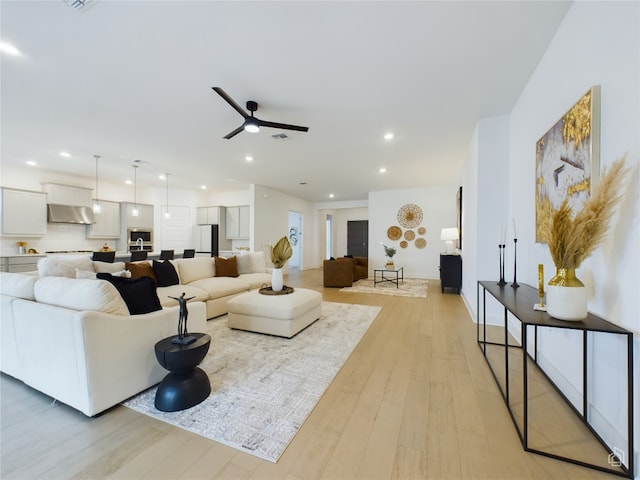 living room with ceiling fan and light hardwood / wood-style floors