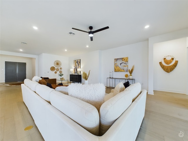 living room with ceiling fan and light hardwood / wood-style flooring