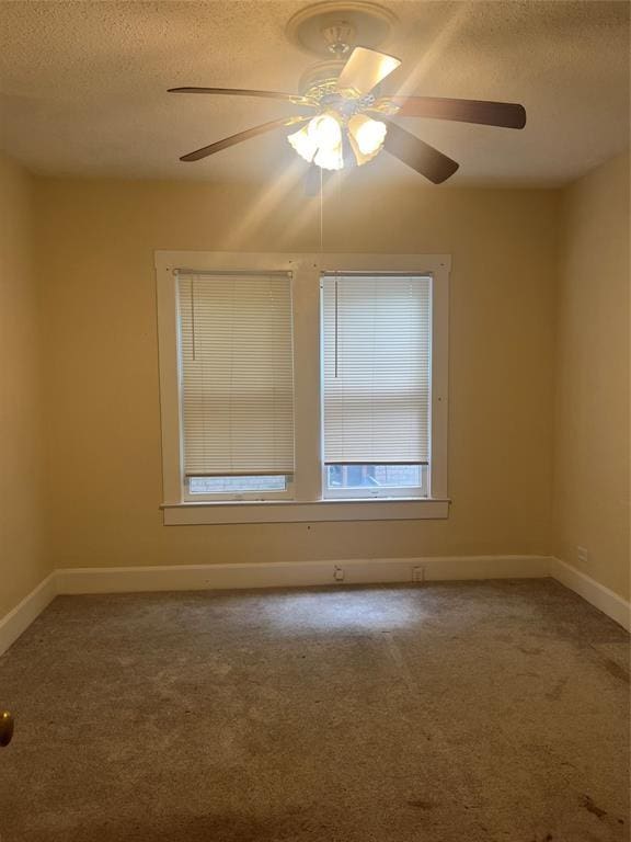 carpeted spare room featuring ceiling fan and a textured ceiling