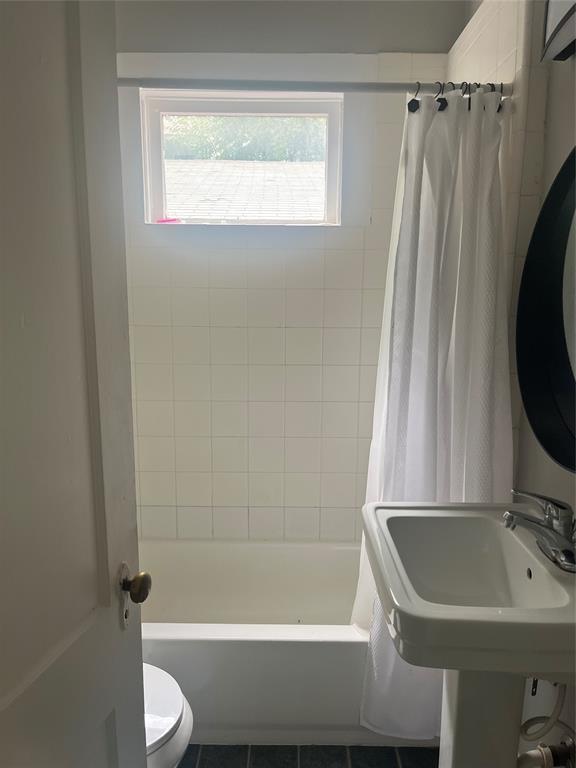 4627 Depew Ave, Austin, TX 78751 - bathroom featuring toilet and shower / bathtub combination with curtain