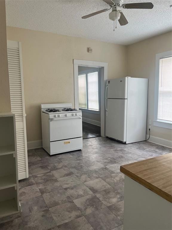 kitchen featuring ceiling fan, white appliances, and a textured ceiling