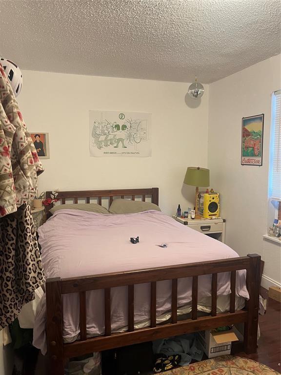 4627 Depew Ave, Austin, TX 78751 - bedroom with wood finished floors and a textured ceiling