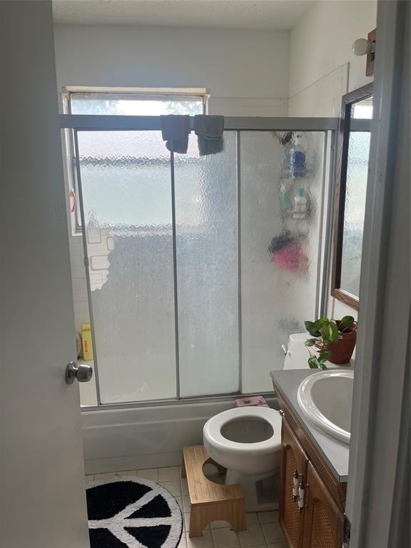 full bathroom featuring tile patterned flooring, vanity, toilet, and shower / bath combination with glass door