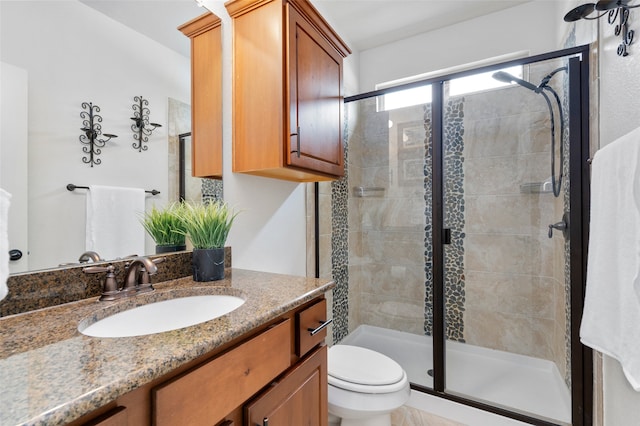 bathroom featuring vanity, toilet, and walk in shower