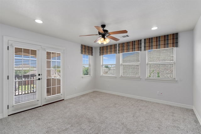 carpeted spare room with ceiling fan and french doors