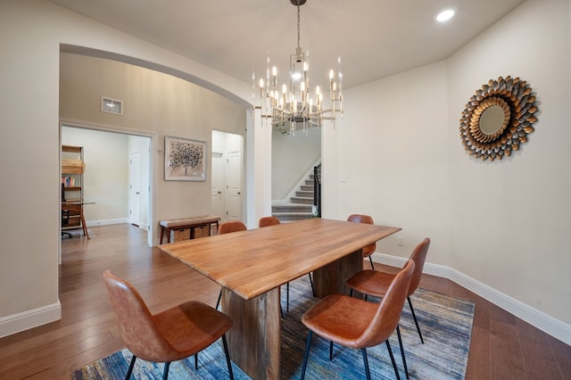 dining space with dark hardwood / wood-style floors and an inviting chandelier