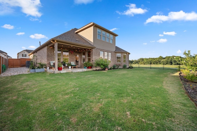 rear view of property with a lawn and a patio area