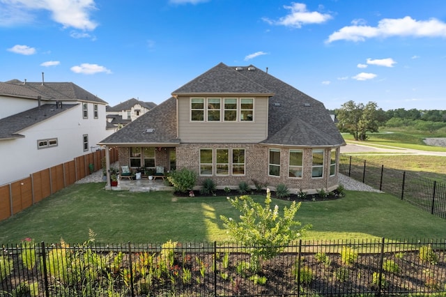 rear view of property with a yard and a patio area