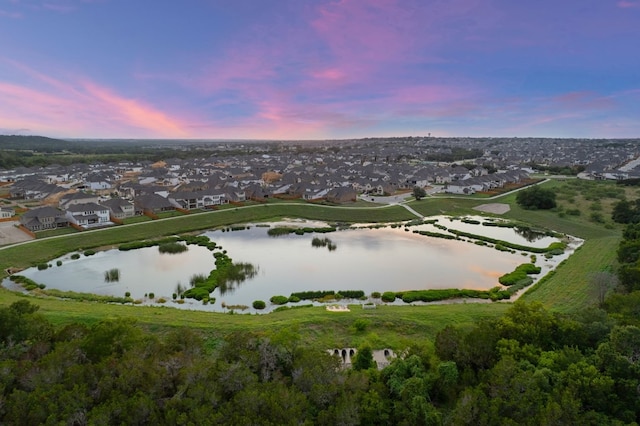 aerial view at dusk featuring a water view