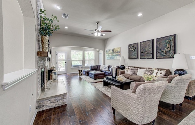 3113 Pasqueflower Pass, Pflugerville, TX 78660 - living area with arched walkways, ceiling fan, a fireplace with raised hearth, dark wood-style flooring, and recessed lighting
