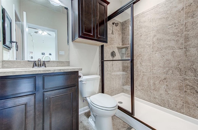 bathroom with an enclosed shower, ceiling fan, toilet, and vanity