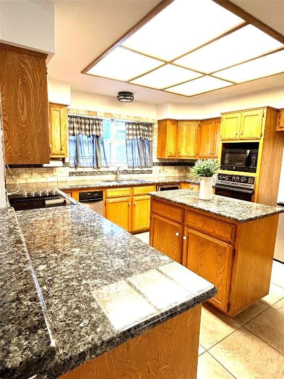 kitchen featuring backsplash, sink, light tile patterned floors, range, and a center island