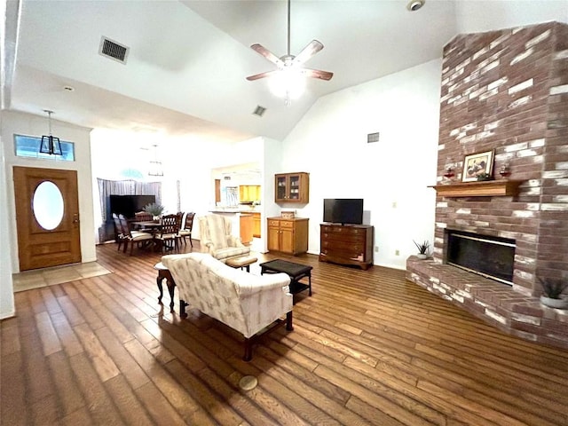 living room featuring a fireplace, dark hardwood / wood-style flooring, and high vaulted ceiling